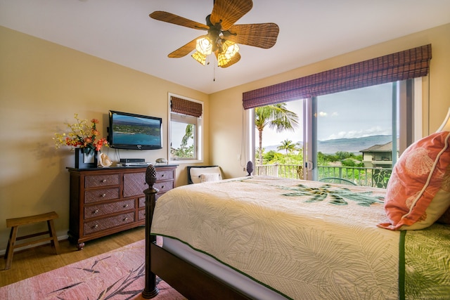 bedroom featuring access to exterior, ceiling fan, and hardwood / wood-style flooring