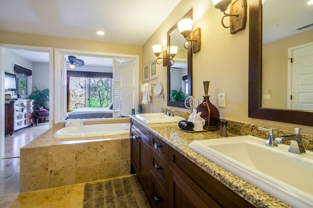 bathroom featuring vanity and tiled tub