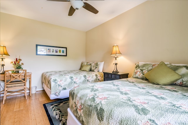 bedroom featuring ceiling fan, lofted ceiling, and light wood-type flooring