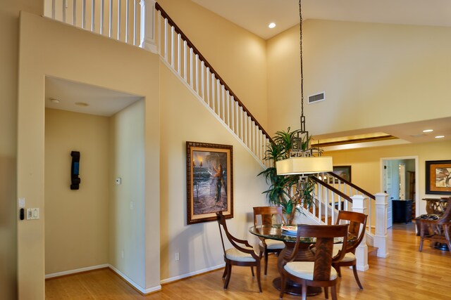 dining room featuring a high ceiling and light hardwood / wood-style flooring