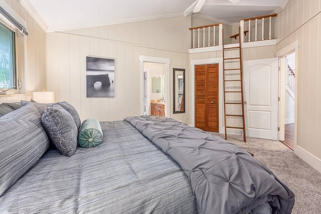 carpeted bedroom featuring connected bathroom, a closet, lofted ceiling, and ornamental molding