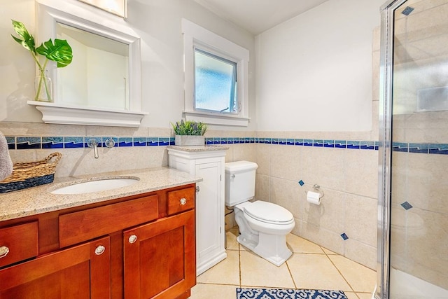 bathroom with vanity, tile patterned floors, toilet, tile walls, and an enclosed shower