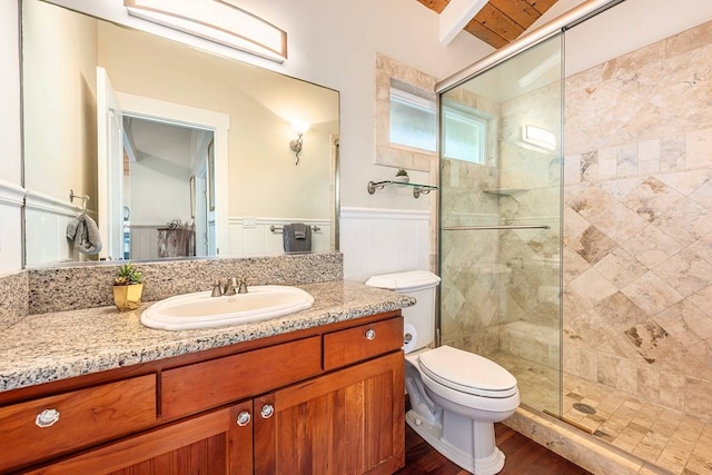 bathroom with hardwood / wood-style floors, toilet, an enclosed shower, and vanity