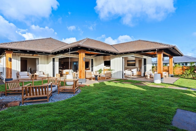 back of house with outdoor lounge area, a patio area, and a yard