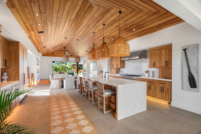 kitchen with wooden ceiling, hanging light fixtures, a spacious island, and range hood