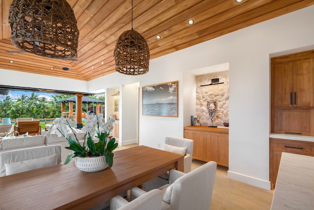 dining area with wood ceiling, high vaulted ceiling, and light hardwood / wood-style flooring