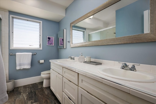 bathroom featuring hardwood / wood-style flooring, vanity, toilet, and walk in shower