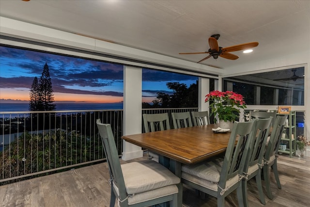 sunroom / solarium featuring ceiling fan and a water view