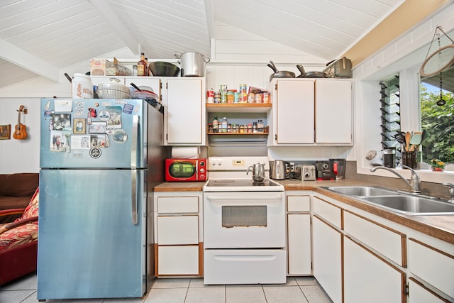 kitchen with stainless steel fridge, sink, electric stove, vaulted ceiling with beams, and white cabinetry