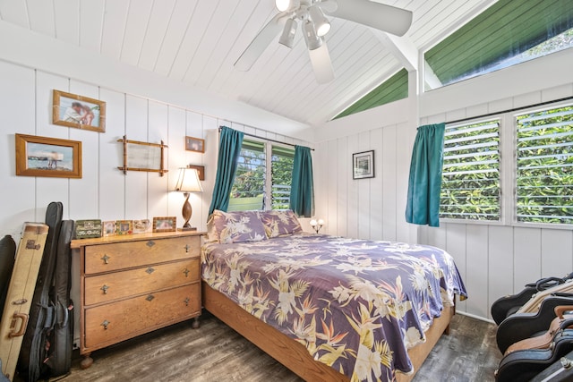 bedroom with vaulted ceiling with beams, ceiling fan, wooden walls, and dark hardwood / wood-style floors