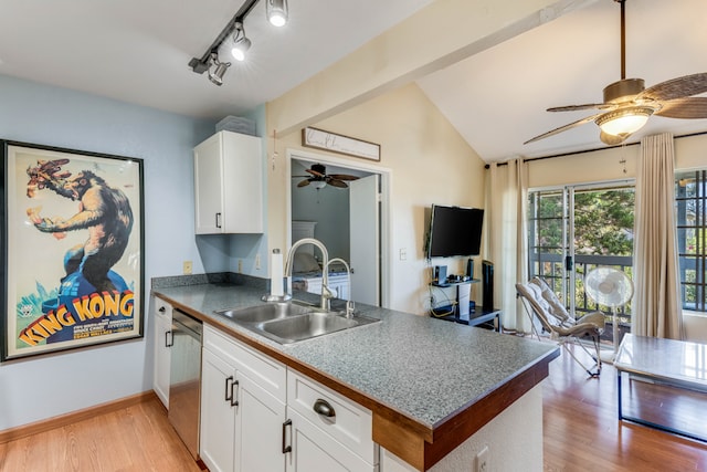 kitchen featuring white cabinets, vaulted ceiling, light hardwood / wood-style flooring, and sink