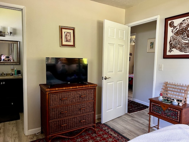 interior space with a textured ceiling, light hardwood / wood-style floors, and sink