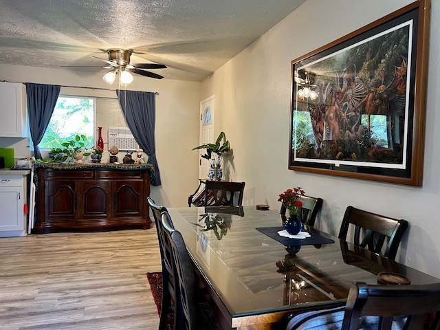 dining space featuring ceiling fan, light hardwood / wood-style floors, and a textured ceiling