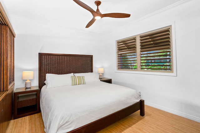 bedroom with ceiling fan, a closet, ornamental molding, and light hardwood / wood-style flooring