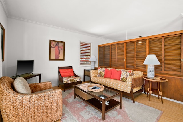 living room featuring light wood-type flooring and ornamental molding