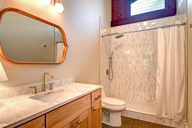 bathroom featuring walk in shower, vanity, wood-type flooring, and toilet