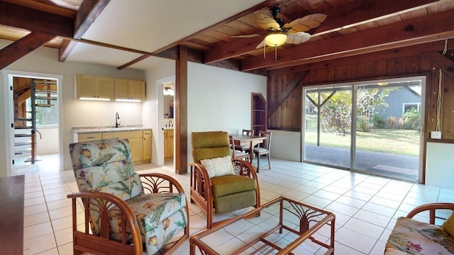 living room with ceiling fan, sink, beamed ceiling, light tile patterned flooring, and wood ceiling