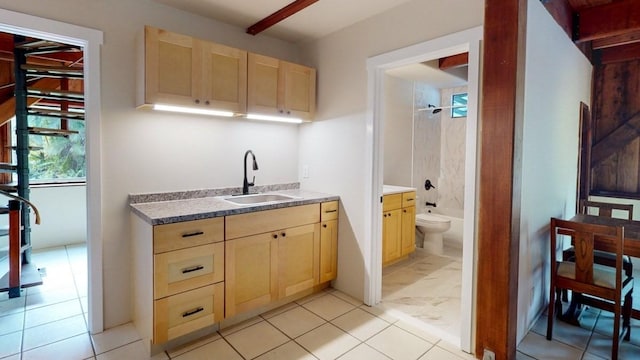 kitchen with light brown cabinetry and sink