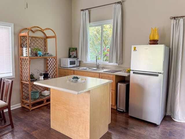 kitchen featuring dark hardwood / wood-style flooring, white appliances, a center island, and sink