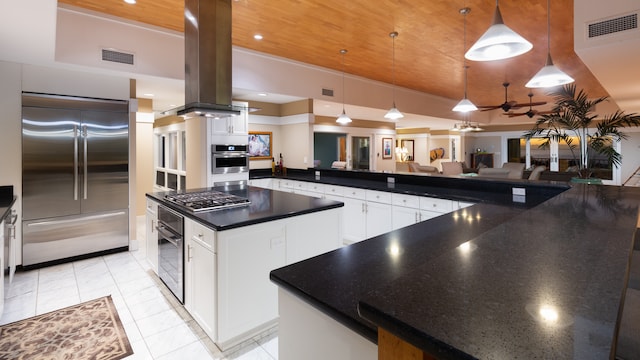 kitchen featuring decorative light fixtures, a center island, stainless steel appliances, and white cabinetry