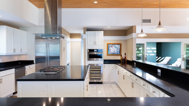 kitchen featuring island exhaust hood, stainless steel appliances, decorative light fixtures, white cabinets, and wine cooler