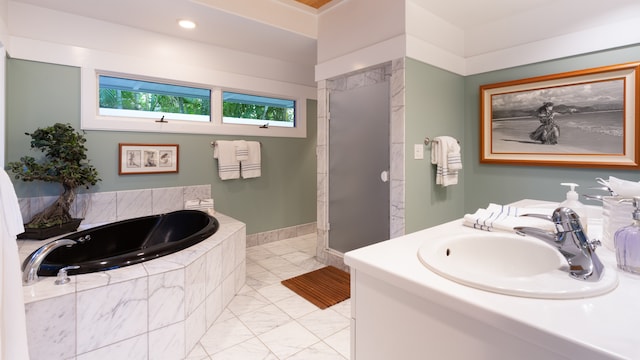 bathroom with vanity and tiled tub