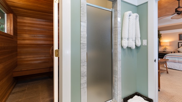 bathroom with wooden ceiling, a shower with door, wooden walls, and ceiling fan