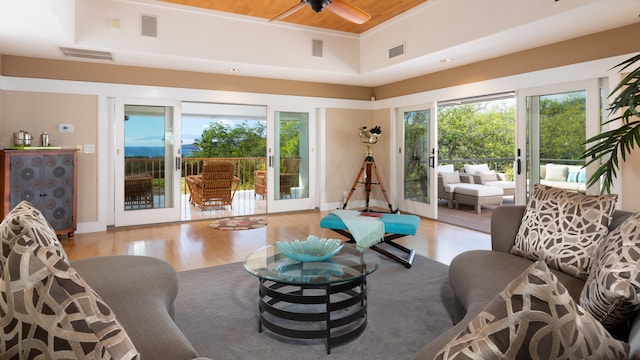 living room with ceiling fan, a healthy amount of sunlight, light wood-type flooring, and wood ceiling