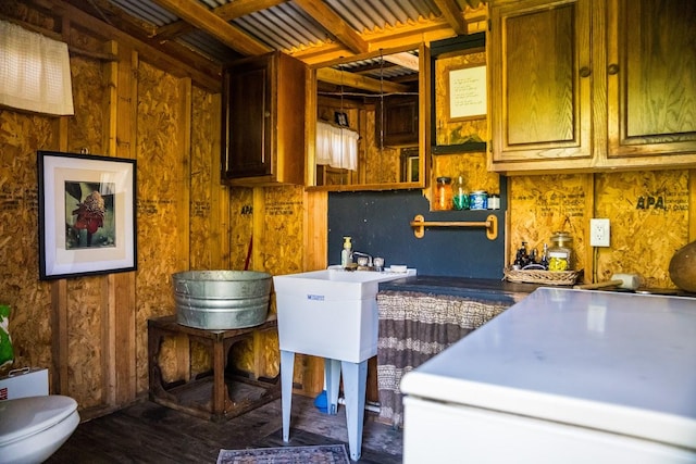 clothes washing area with dark wood-type flooring