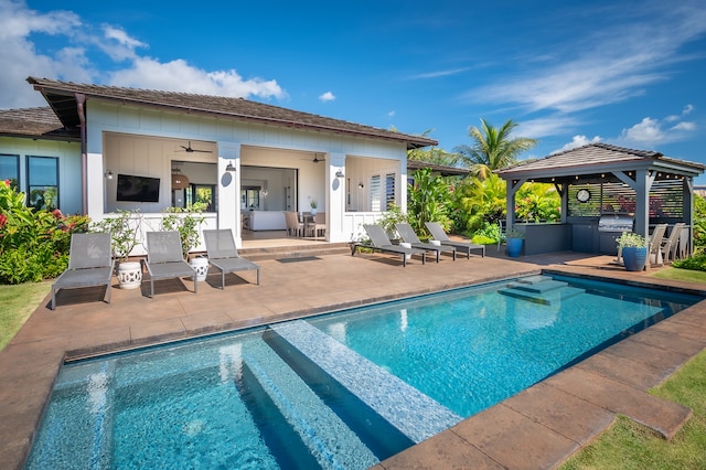 view of pool with a gazebo, a patio area, ceiling fan, and an outdoor kitchen