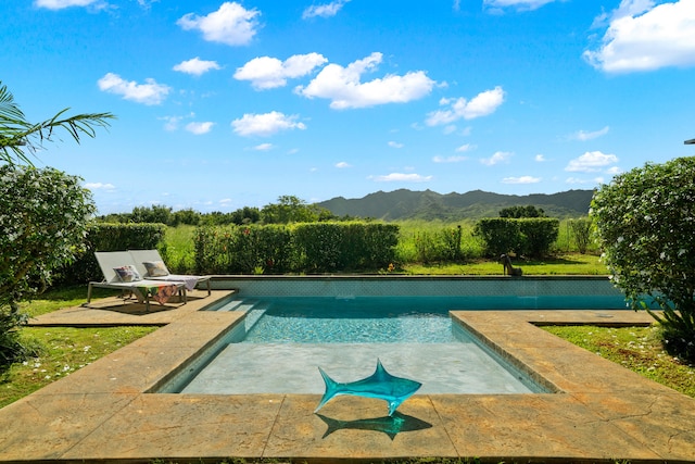 view of swimming pool with a mountain view and a patio