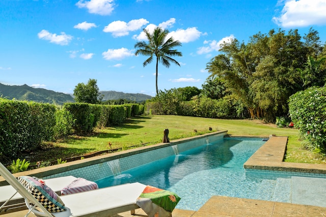 view of swimming pool featuring a lawn, a mountain view, and pool water feature