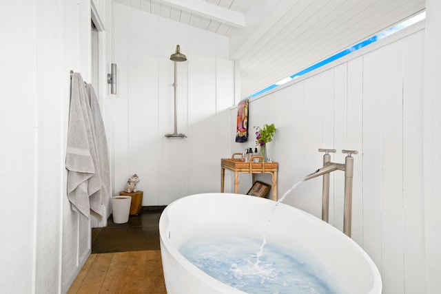 bathroom with hardwood / wood-style flooring, a bathtub, beam ceiling, and wood ceiling