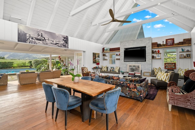 dining area with ceiling fan, hardwood / wood-style flooring, beamed ceiling, and high vaulted ceiling