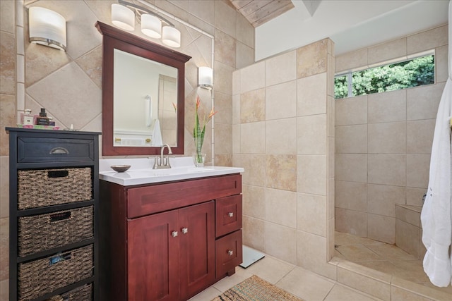 bathroom featuring tile patterned flooring, vanity, and tile walls