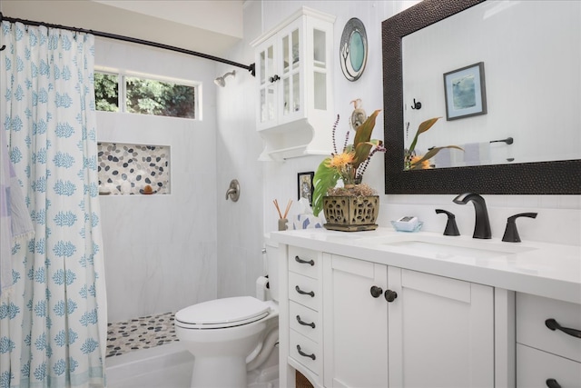 bathroom with curtained shower, vanity, and toilet