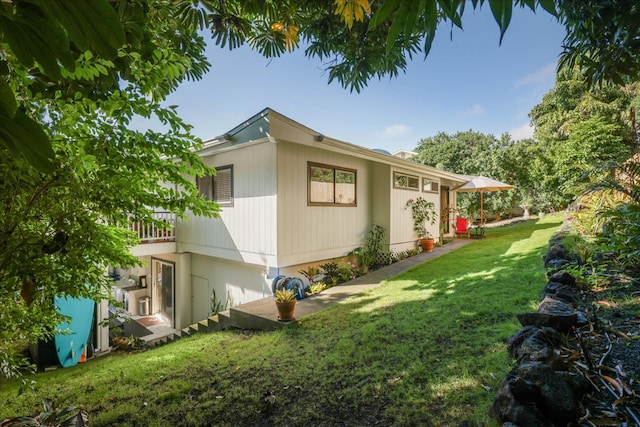 view of side of home with a yard