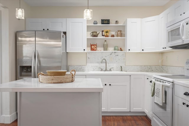 kitchen featuring pendant lighting, white cabinetry, white appliances, and dark wood-type flooring