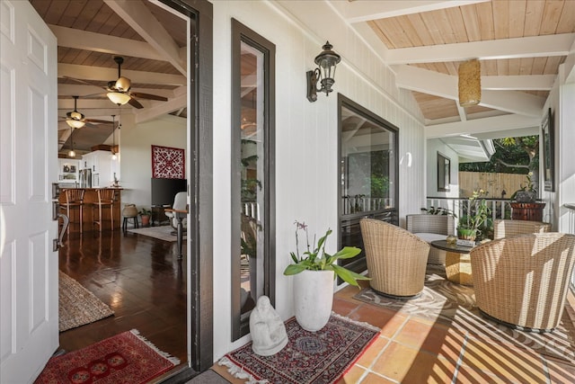 exterior space featuring vaulted ceiling with beams, ceiling fan, and wooden ceiling