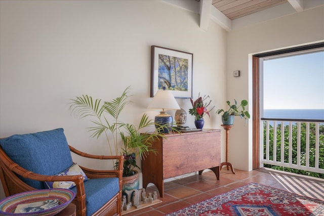 sitting room featuring beamed ceiling, tile patterned flooring, a water view, and wood ceiling