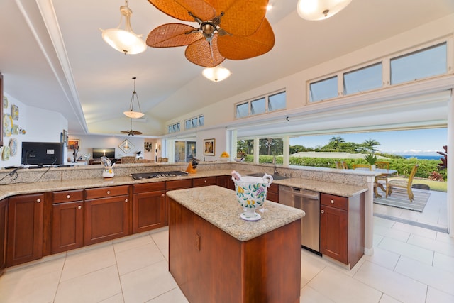 kitchen with stainless steel appliances, a kitchen island, decorative light fixtures, vaulted ceiling, and light tile patterned floors