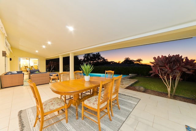 dining space with light tile patterned floors and lofted ceiling