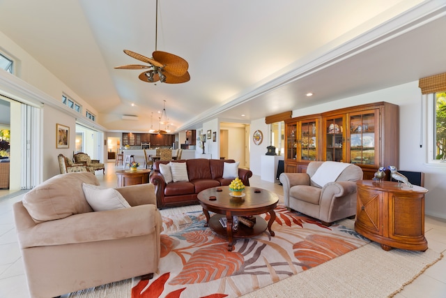 tiled living room featuring ceiling fan with notable chandelier and vaulted ceiling