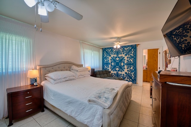 bedroom with ceiling fan, light tile patterned flooring, and connected bathroom