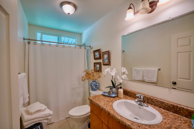 bathroom with tile patterned floors, vanity, toilet, and walk in shower