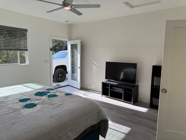 bedroom with access to exterior, hardwood / wood-style floors, and ceiling fan