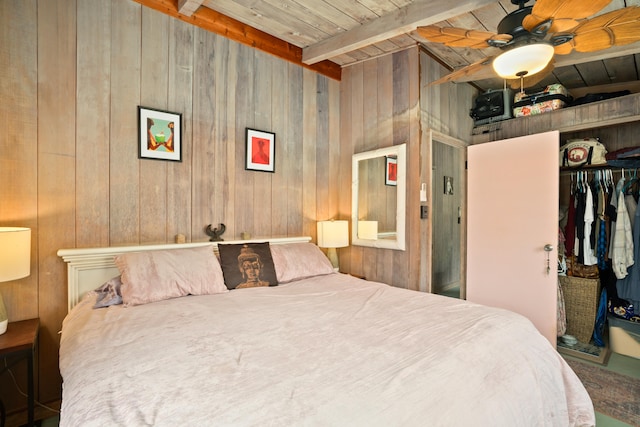 bedroom featuring ceiling fan, wooden ceiling, vaulted ceiling with beams, wooden walls, and a closet