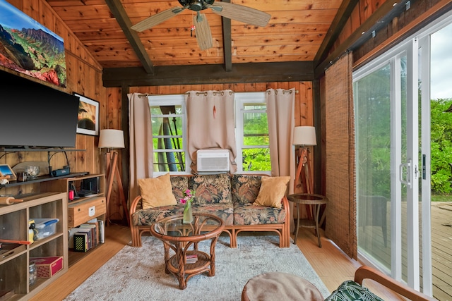 living room with vaulted ceiling with beams, wood walls, ceiling fan, and light hardwood / wood-style floors