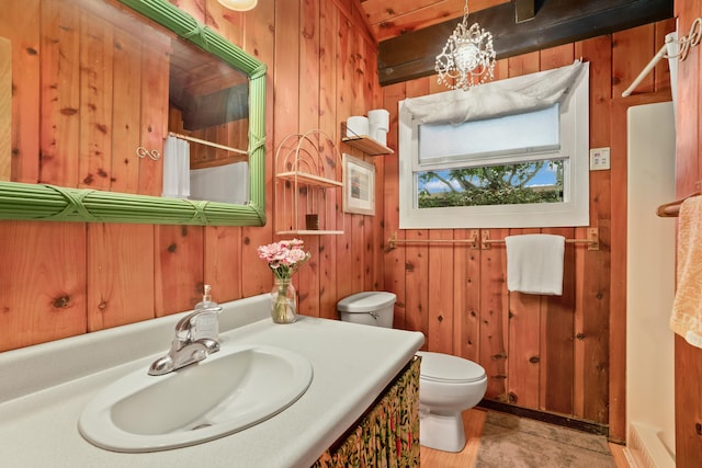 bathroom with wood walls, vanity, a shower with shower curtain, and toilet