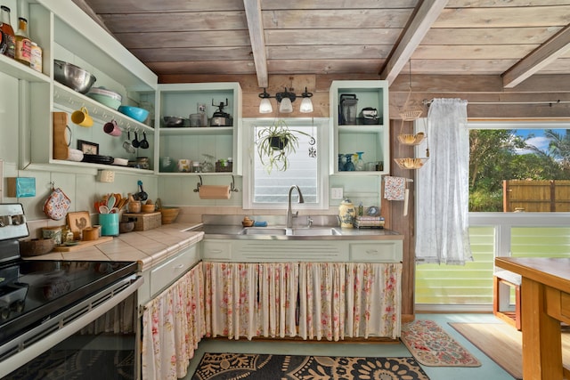 kitchen featuring tile countertops, electric range, plenty of natural light, and sink